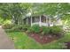 Cozy home with a covered front porch, well-manicured lawn, and lush landscaping creating a charming curb appeal at 501 E Tremont Ave, Charlotte, NC 28203