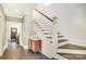 Hallway with dark hardwood floors, stylish wallpaper and an open staircase, creating an inviting transition space at 501 E Tremont Ave, Charlotte, NC 28203