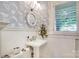 Charming powder room with patterned wallpaper, a decorative mirror, and a pedestal sink at 501 E Tremont Ave, Charlotte, NC 28203