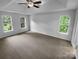 Large main bedroom with tray ceiling, carpet, ceiling fan, and multiple windows at 524 N Portman Ln, Fort Mill, SC 29708
