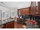 Stylish bar area with cherry cabinets, granite counters, and wine storage at 5425 Closeburn Rd # 208, Charlotte, NC 28210