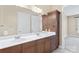 Bathroom features double vanity, a large mirror, and wooden cabinets at 5425 Closeburn Rd # 208, Charlotte, NC 28210