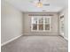 Bright, carpeted room with large window and ceiling fan at 5425 Closeburn Rd # 208, Charlotte, NC 28210