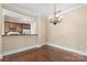 Bright dining area with hardwood floors, decorative chandelier, and an open layout flowing to the kitchen at 5425 Closeburn Rd # 208, Charlotte, NC 28210