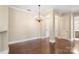 Inviting living area featuring hardwood floors, chandelier, neutral color palette, and access to hallway at 5425 Closeburn Rd # 208, Charlotte, NC 28210