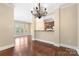 Open-concept living area featuring hardwood floors, ample natural light, and a sleek kitchen in the background at 5425 Closeburn Rd # 208, Charlotte, NC 28210