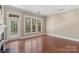 Bright, open living room with hardwood floors, large windows and a door to the outside at 5425 Closeburn Rd # 208, Charlotte, NC 28210