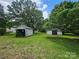 Spacious backyard featuring two sheds, mature trees, and green grass at 562 W Wilson Ave, Mooresville, NC 28115
