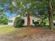 Rear of home with a brick chimney and lush trees at 562 W Wilson Ave, Mooresville, NC 28115