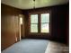Bedroom features wood paneling, carpet, and two windows that provide natural light at 562 W Wilson Ave, Mooresville, NC 28115