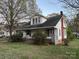 Two-story home with covered porch, mature trees, and brick chimney at 562 W Wilson Ave, Mooresville, NC 28115