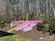 Landscaped backyard featuring stone steps surrounded by vibrant flowers and mature trees at 5812 Dinsmore Ln, Belmont, NC 28012