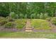 Beautiful backyard featuring stone steps and lush greenery leading to a wooded area at 5812 Dinsmore Ln, Belmont, NC 28012