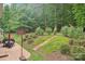 Expansive backyard with stone patio, outdoor seating, basketball hoop, and landscaped steps at 5812 Dinsmore Ln, Belmont, NC 28012