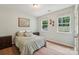This bedroom boasts two windows, hardwood floors, and a comfortable-looking bed with decorative pillows at 5812 Dinsmore Ln, Belmont, NC 28012
