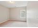 This neutral bedroom has natural light from a window, plush carpet, and neutral decor, creating a cozy and restful atmosphere at 5812 Dinsmore Ln, Belmont, NC 28012