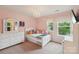 This pink themed bedroom features a chandelier, large window and a white dresser offering ample storage at 5812 Dinsmore Ln, Belmont, NC 28012