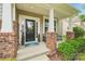 Inviting front porch with brick columns, seating, and decorative greenery for a welcoming entrance at 5812 Dinsmore Ln, Belmont, NC 28012