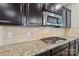 Modern kitchen with granite countertops, tile backsplash, and stainless steel gas cooktop at 5812 Dinsmore Ln, Belmont, NC 28012
