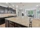 Granite kitchen island with dark cabinets and stainless appliances in open concept kitchen at 5812 Dinsmore Ln, Belmont, NC 28012