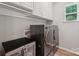 Well-equipped laundry room with washer, dryer, beverage fridge and overhead cabinets at 5812 Dinsmore Ln, Belmont, NC 28012