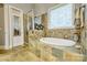 Elegant bathroom featuring a soaking tub with decorative tile surround, a glass shower, and tile floors at 5826 Natoma Rd, Lake Wylie, SC 29710