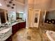 Bright bathroom featuring granite counters, dual sinks, a soaking tub and glass-enclosed shower at 5826 Natoma Rd, Lake Wylie, SC 29710