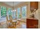 Sun-filled dining area features large windows with backyard views, hardwood floors, and classic furniture at 5826 Natoma Rd, Lake Wylie, SC 29710