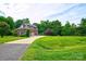 Charming two-story brick home with mature trees, driveway and manicured lawn on a sunny day at 5826 Natoma Rd, Lake Wylie, SC 29710