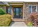 Inviting front door with brick surround, decorative plants, and stylish exterior lighting at 5826 Natoma Rd, Lake Wylie, SC 29710