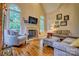 Cozy living room with fireplace, hardwood floors, comfortable seating, and natural light from large windows at 5826 Natoma Rd, Lake Wylie, SC 29710