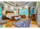 Spacious main bedroom with hardwood floors, a tray ceiling, large windows, and elegant furnishings at 5826 Natoma Rd, Lake Wylie, SC 29710