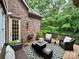 Cozy outdoor patio with wicker furniture, a patterned rug, and views of the lush backyard at 5826 Natoma Rd, Lake Wylie, SC 29710