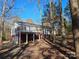 Exterior view of the home with a deck overlooking the backyard's natural landscape at 7154 Woodcock Trl, Stanley, NC 28164