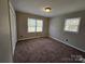 Carpeted bedroom with large windows and neutral paint scheme provides a cozy, tranquil atmosphere at 7154 Woodcock Trl, Stanley, NC 28164