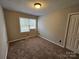Bedroom with a window and closet space, featuring soft carpeting at 7154 Woodcock Trl, Stanley, NC 28164