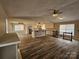 Open concept living area blends kitchen and living room with wood floors and modern finishes at 7154 Woodcock Trl, Stanley, NC 28164