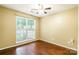 Bright bedroom featuring hardwood floors, a ceiling fan, and a large window offering ample natural light at 7206 Stoney Place Ct, Charlotte, NC 28262