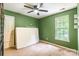 Bedroom with green walls featuring a ceiling fan, carpeted floors, closet and natural light from the window at 7206 Stoney Place Ct, Charlotte, NC 28262