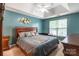 Main bedroom with a tray ceiling, ceiling fan, large bed, and a window providing natural light at 7206 Stoney Place Ct, Charlotte, NC 28262