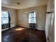 View of a bedroom with hard wood floors, needs significant renovation, featuring two windows at 722 S Weldon St, Gastonia, NC 28052
