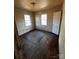 View of a bedroom, needs significant renovation, featuring two windows and a door at 722 S Weldon St, Gastonia, NC 28052