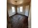 View of a bedroom, needs significant renovation, featuring two windows and a door at 722 S Weldon St, Gastonia, NC 28052