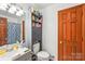 Cozy bathroom featuring modern fixtures, toilet, and storage cabinet with shelves above the commode at 8504 Knollwood Cir, Charlotte, NC 28213