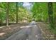 Long driveway leading to a house surrounded by lush greenery and mature trees at 8504 Knollwood Cir, Charlotte, NC 28213
