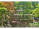 Two-story home with a covered front porch surrounded by lush greenery and mature trees at 8504 Knollwood Cir, Charlotte, NC 28213