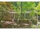 Two-story home featuring a covered front porch and brick foundation nestled among mature trees at 8504 Knollwood Cir, Charlotte, NC 28213