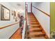 Hallway with wood floors, staircase, and art-adorned walls leading to various rooms at 8504 Knollwood Cir, Charlotte, NC 28213