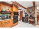 Kitchen with wood cabinets, double oven, brick wall, and a view to the entryway at 8504 Knollwood Cir, Charlotte, NC 28213