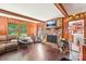 Cozy living room with hardwood floors, a stone fireplace, and wood-paneled walls at 8504 Knollwood Cir, Charlotte, NC 28213